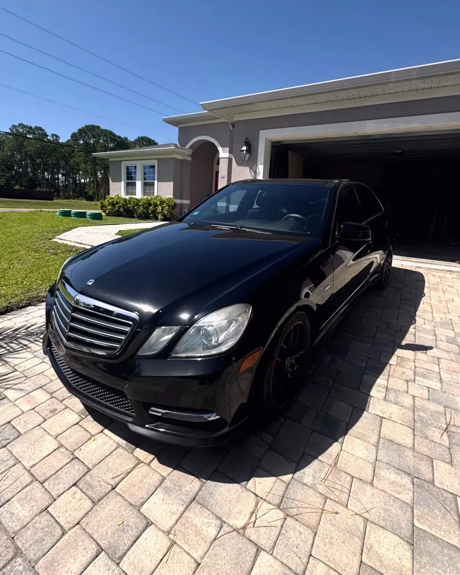 A black Mercedes E-Class detailed on a paver driveway