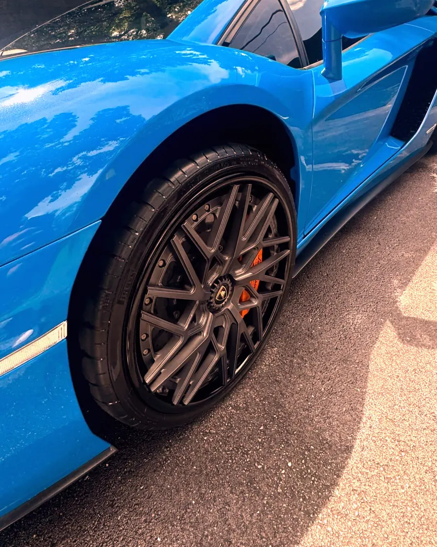 A blue Lamborghini Aventador wheel with carbon details