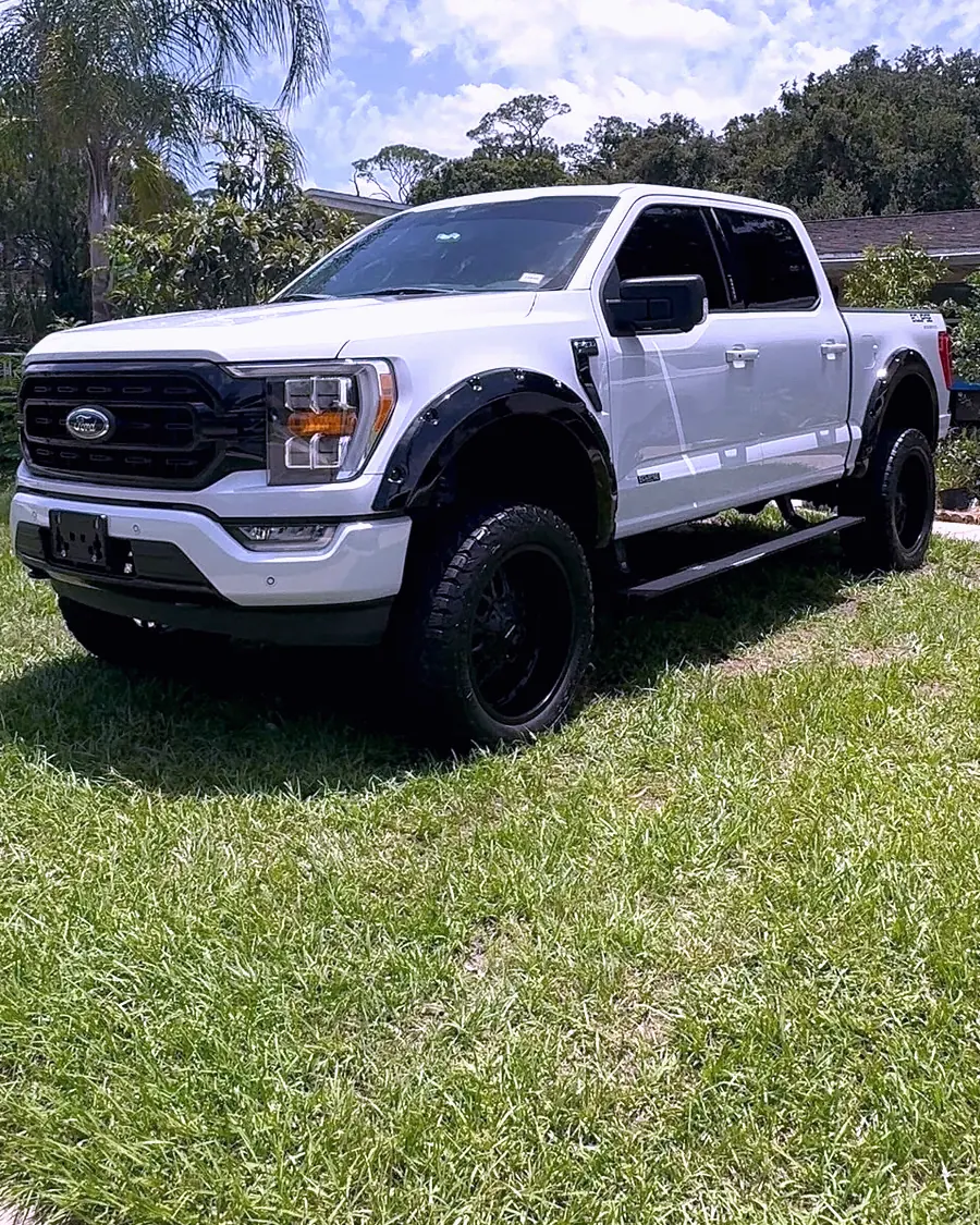 A lifted white Ford F-150 detailed at a client home