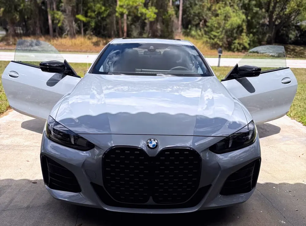 A gray BMW 4 Series with both doors open, detailed inside and out